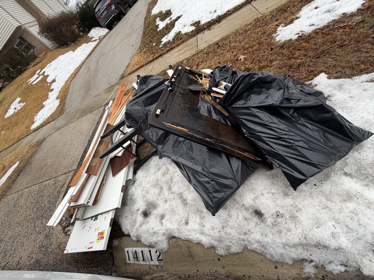 Debris bags and boards on driveway for pickup