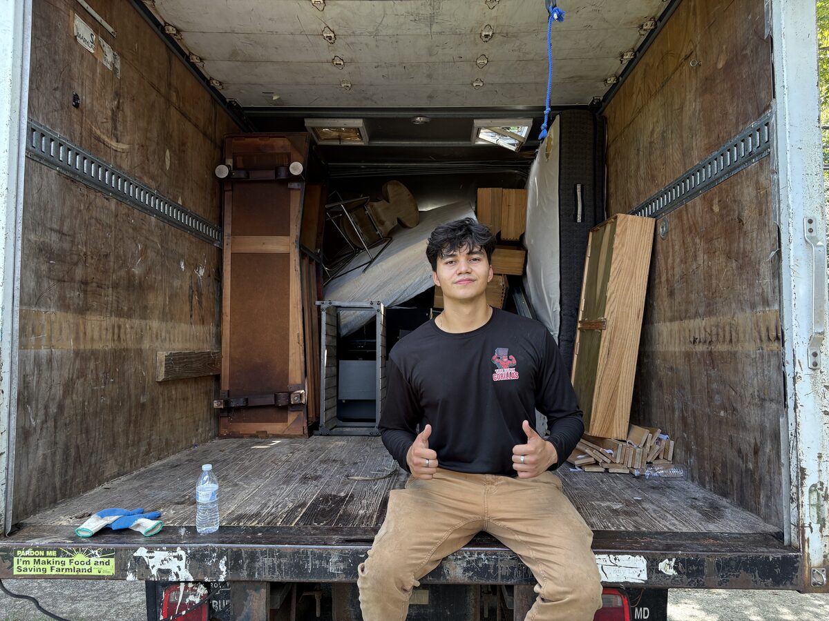 Crew member with loaded junk removal truck